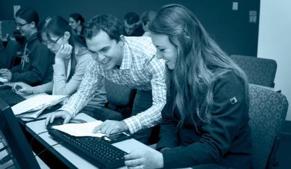 Students in a computer lab with someone helping