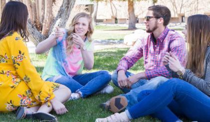 A group of student chatting in the grass