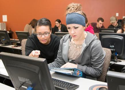 Two students working together at a computer.