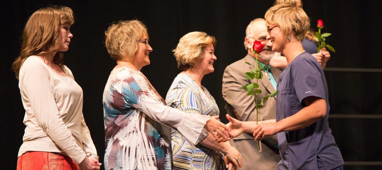 Nursing student shakes her professor's hands during nurses pinning.