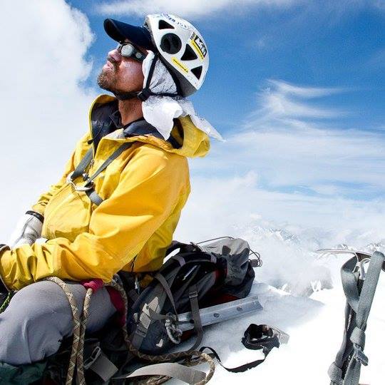 Darran Wells in his outdoor winter gear sitting in the snow.