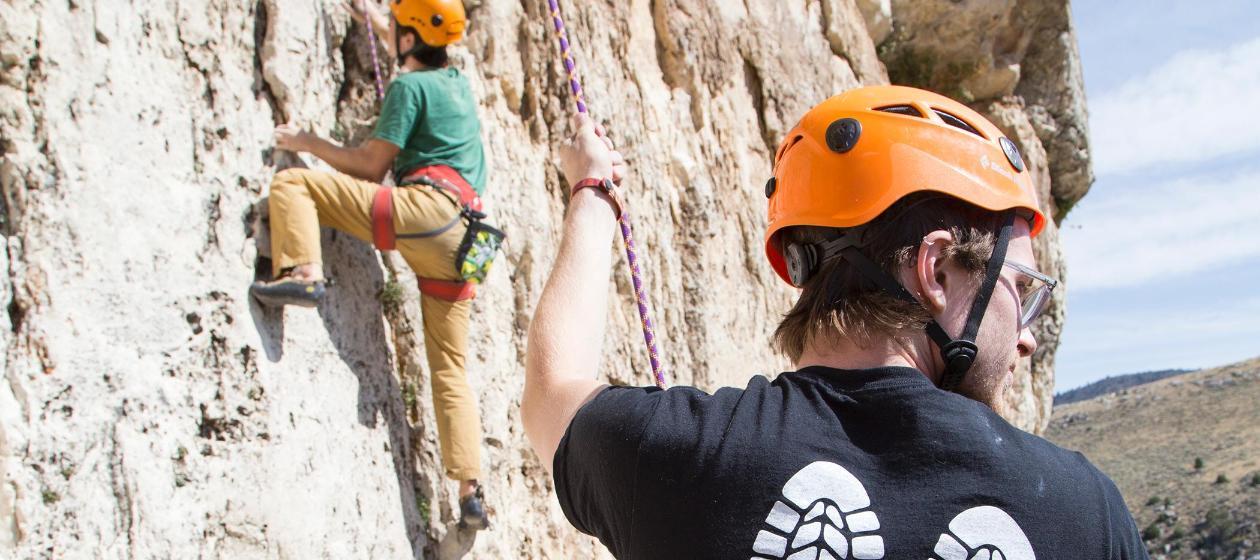 A student belays another student as he rock climbs in Sinks Canyon. 