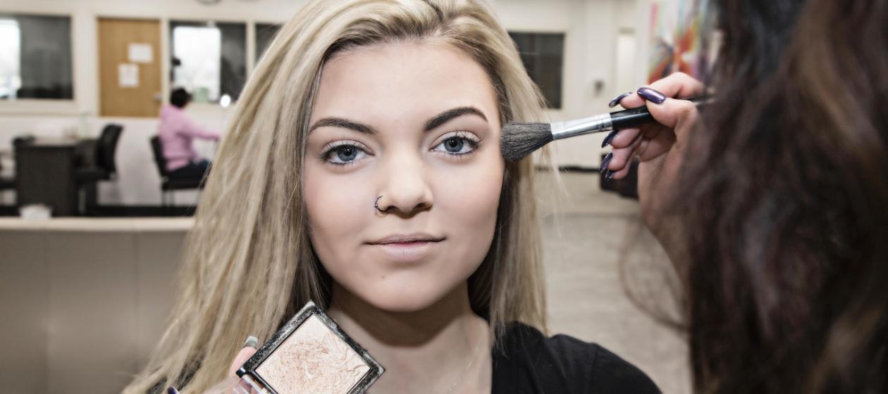 A student practices makeup application techniques