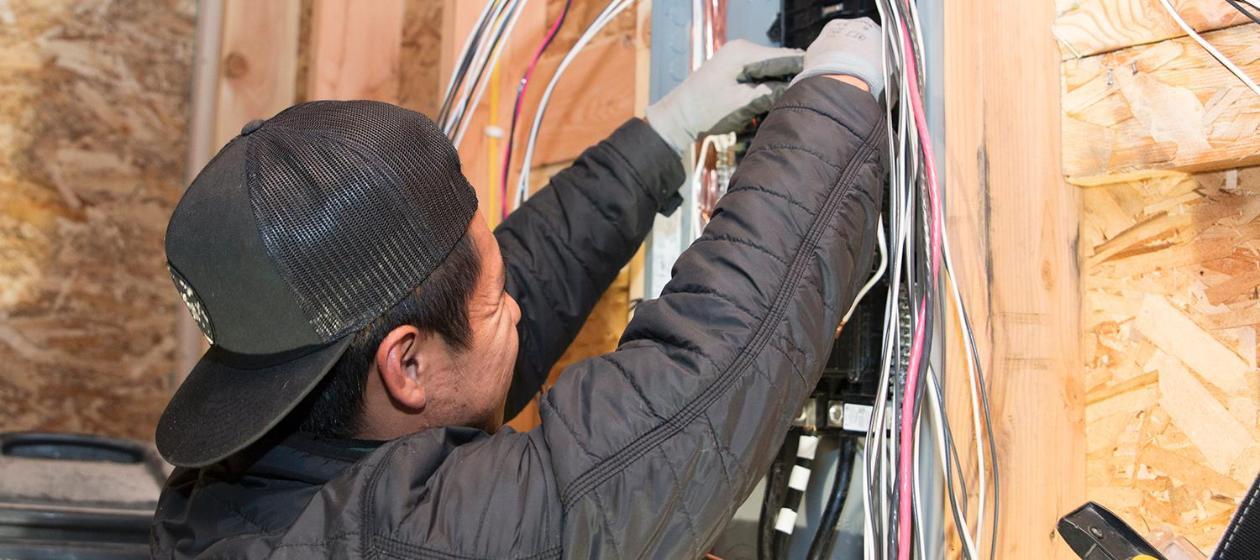 A student installing a breaker box