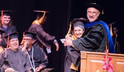 Dr. Brad Tyndall hugs a student at graduation