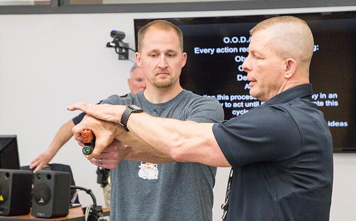 photo of Chuck Carr showing Scott McFarland how to take a weapon away