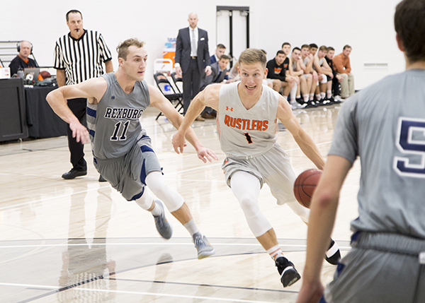 CWC men's basketball player dribbling past a defender.