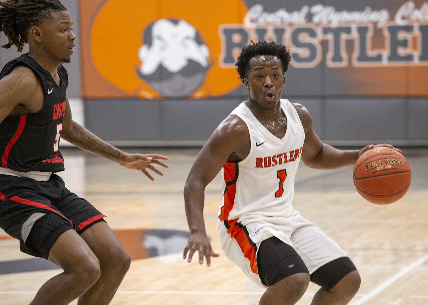 CWC men's basketball player keeps the basketball away from the other team