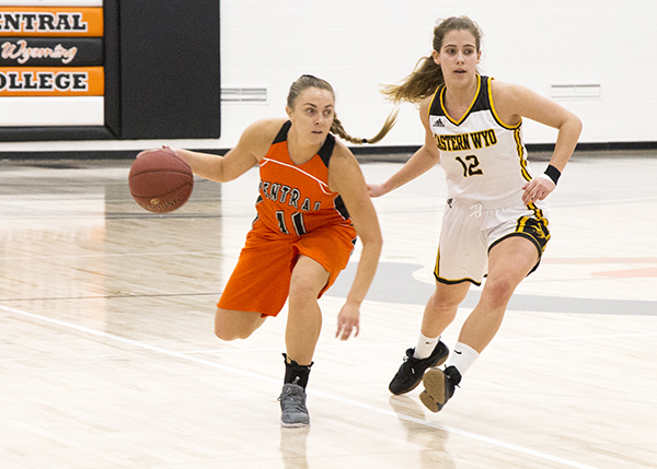 Two women on opposing teams playing basketball