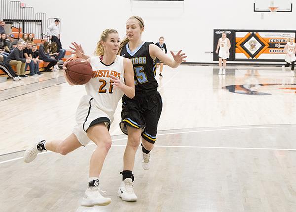 Two women on opposing teams on the basketball court