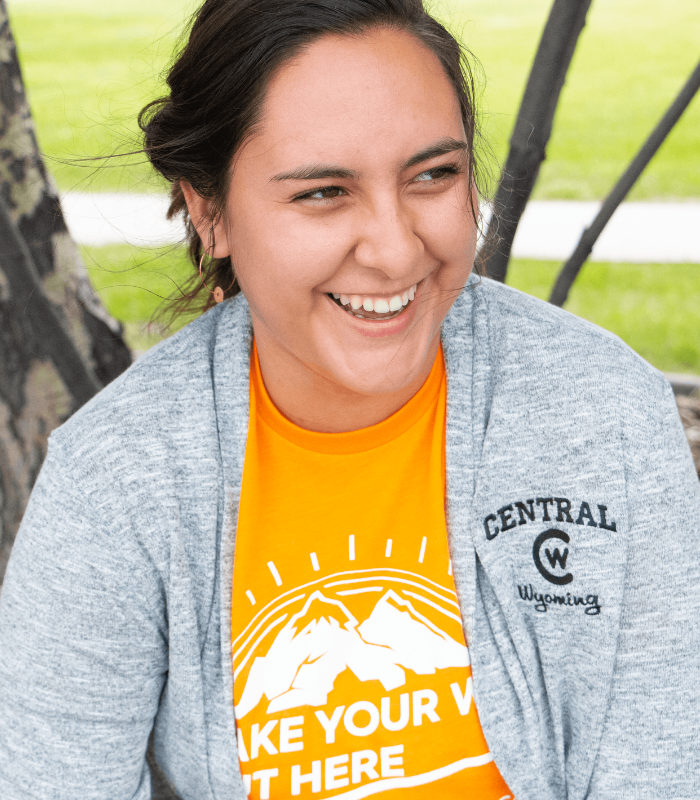 A student sits outside with CWC gear on