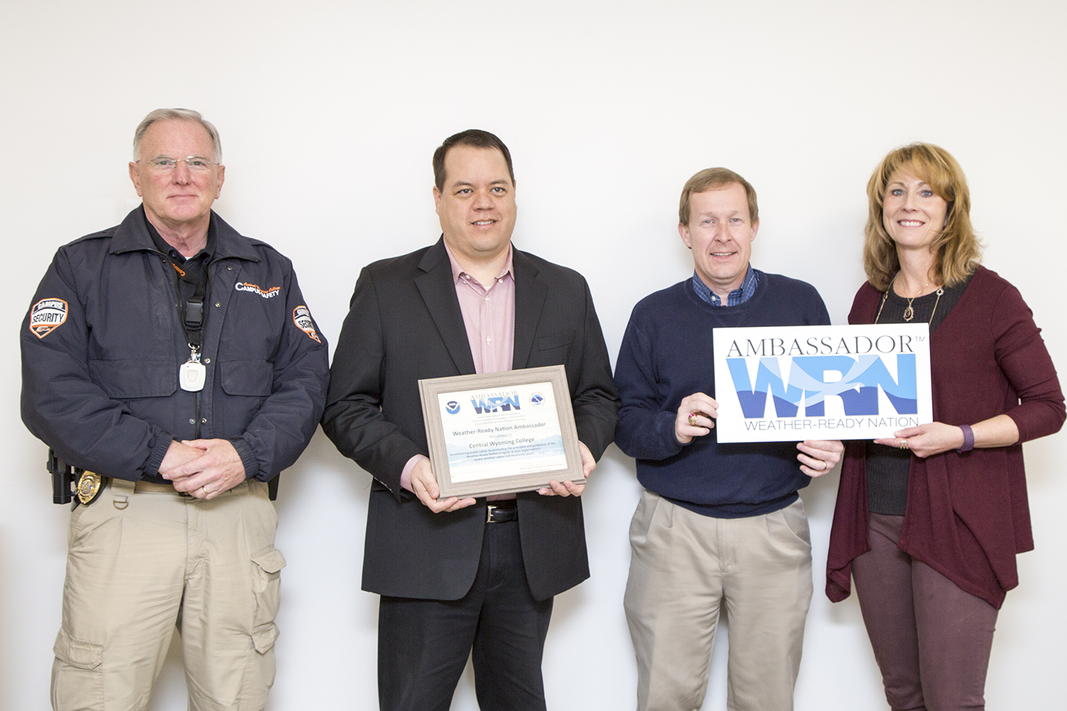 Dave Hockett campus security, Willie Noseep vice president of administrative service and Lori Ridgway marketing director accept a certificate from Tim Troutman from the National Ocieanic and Atmospheric Administration